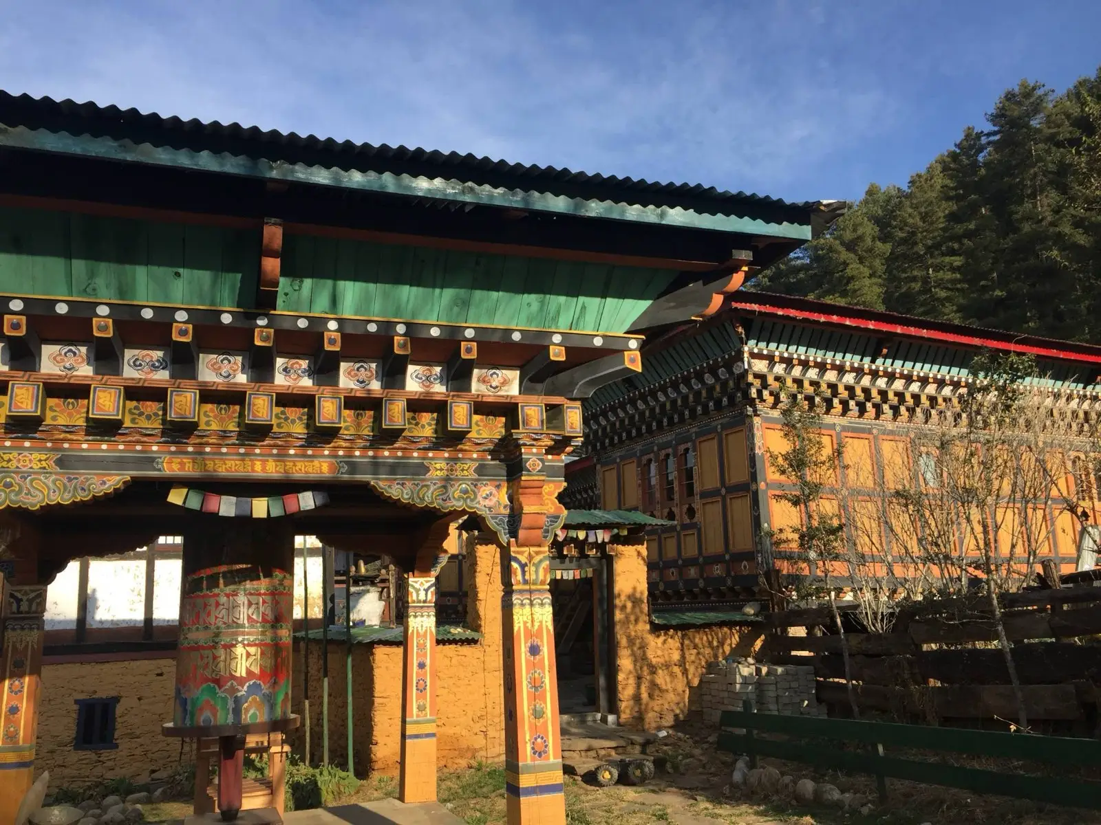 Painted temple courtyard with a large prayer wheel